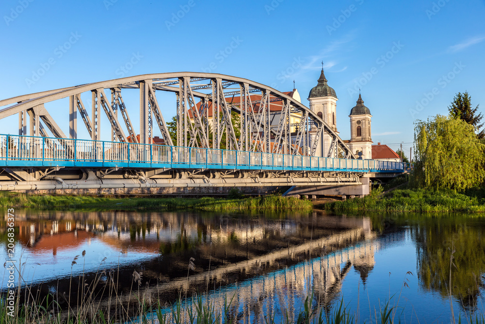 Fototapeta View at bridge over the Narew river and baroque Church of the Holy Trinity in Tykocin town, Podlasie, Poland