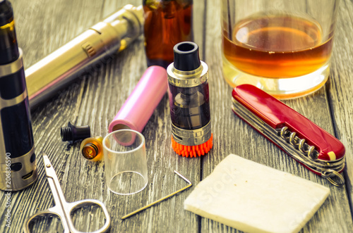 Still life with e-cig and jiuce on the wooden background photo