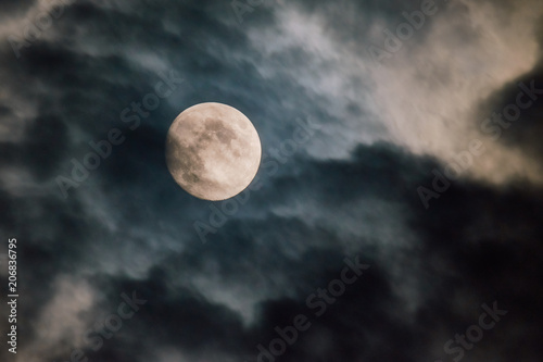 beinahe Vollmond hinter grau schwarzen Regenwolken teilweise verschleiert am 28.05.2018