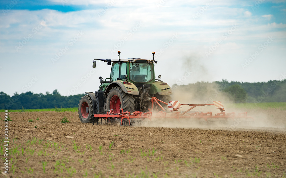 tracteur en activité d'aération du sol dans le champ la poussière vole tracteur en activité d'aération du sol dans le champ la poussière vole