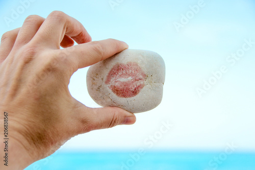 Women hand holding a stone with a kiss, holidays in Greece, Zakynthos