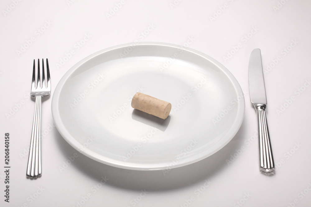 alcoholism concept: wine cork on an empty white dish isolated on white background alcoholism concept: wine cork on an empty white dish isolated on white background