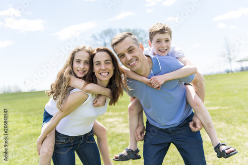 Family of four outdoors in a field having fun