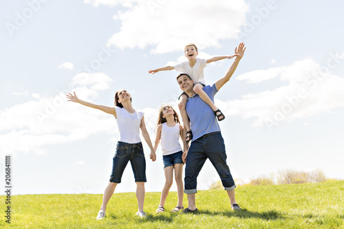 Family of four outdoors in a field having fun