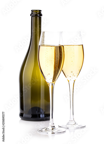 Two glasses of champagne on the background of brown bottles close-up isolated on a white.