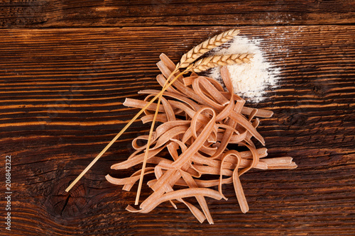 Wholegrain spaghetti on wooden table.