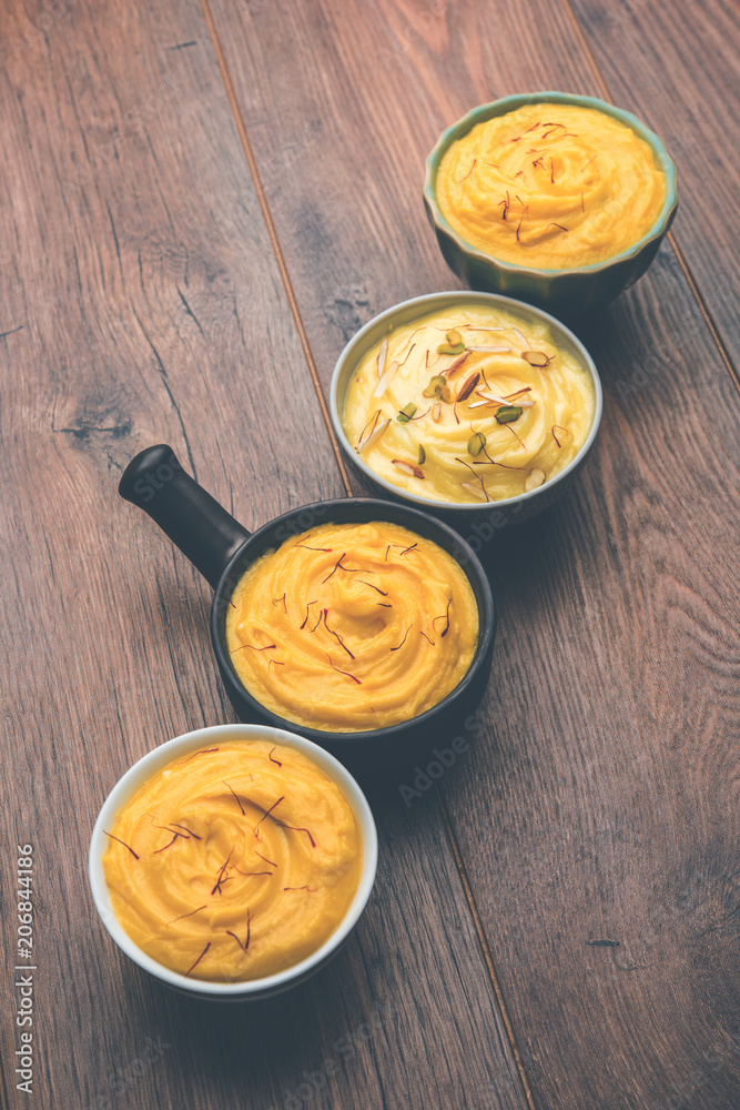 Fototapeta premium Shrikhand & Amrakhand served in different size bowl in group. Selective focus