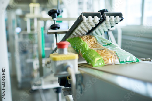 Foto Close up of production process at modern food factory, focus on macaroni bag rea
