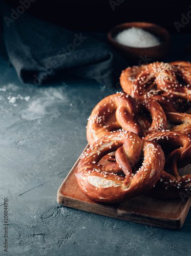 Freshly baked homemade soft pretzel with salt on rustic table. Perfect for Octoberfest. Toned image.