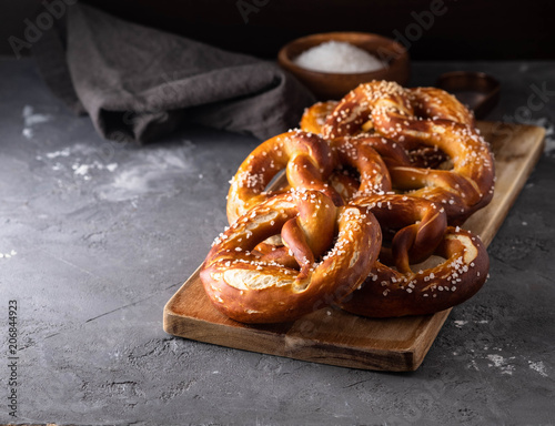 Fototapeta Freshly baked homemade soft pretzel with salt on rustic table