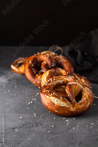Freshly baked homemade soft pretzel with salt on rustic table. Perfect for Octoberfest. 