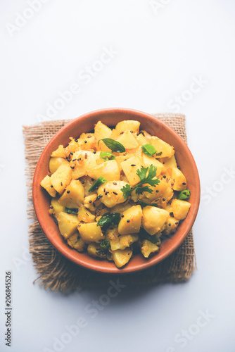 Chatpate Masala Aloo Sabzi fry OR Bombay potatoes served in a bowl, selective focus photo