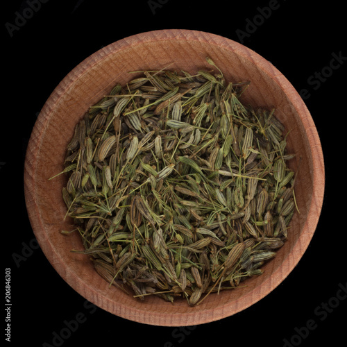 iseeds of fennel n wooden cup isolated on black. top view