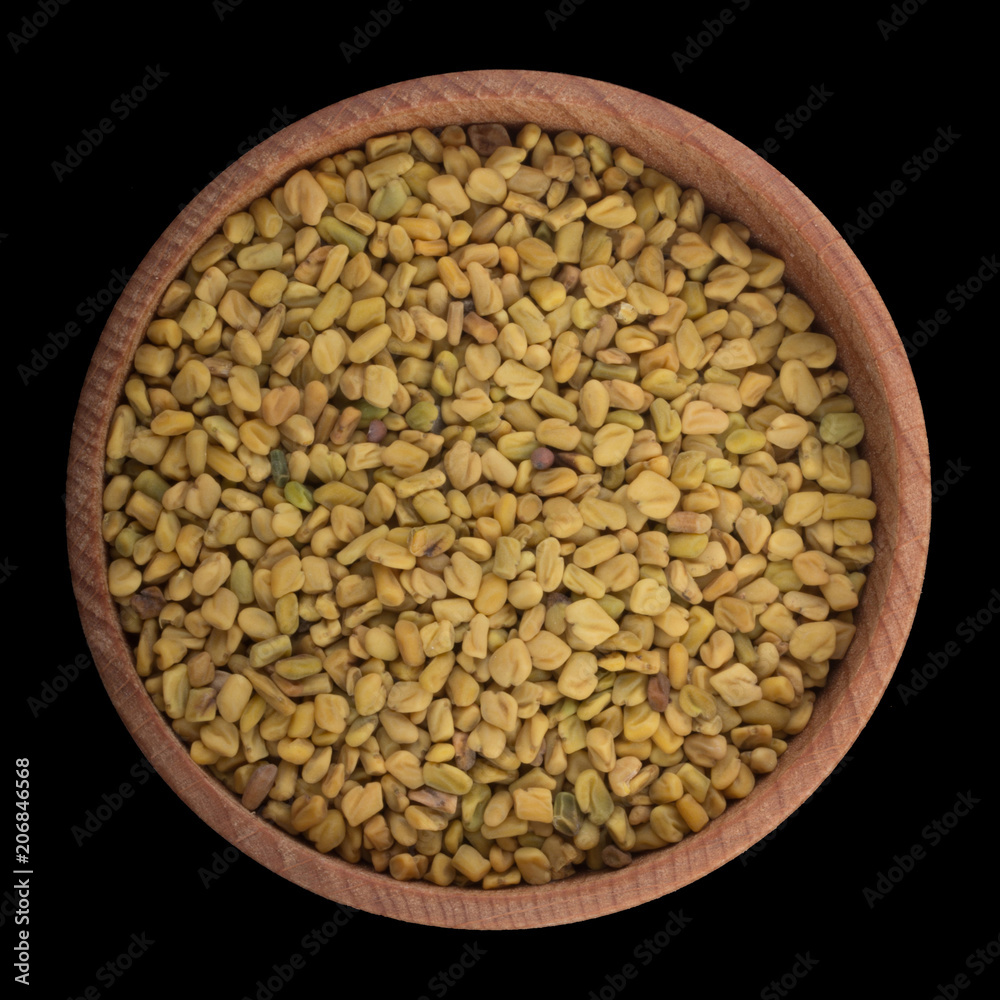 seeds of Fenugreek in wooden cup isolated on black. top view seeds of Fenugreek in wooden cup isolated on black. top view