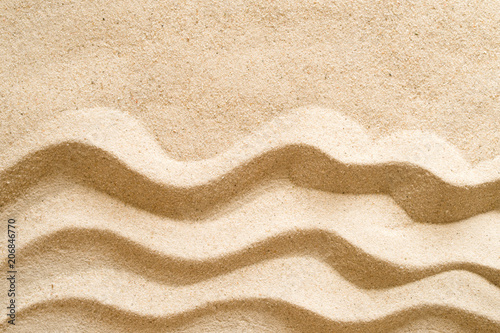 Texture of sand. The drawing of a wave on sand