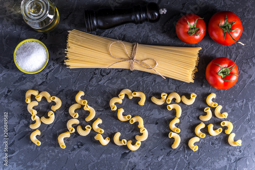 Uncooked pasta cavatappi and spaghetti with ingredients for tomato sauce. Concept of the composition of food design.