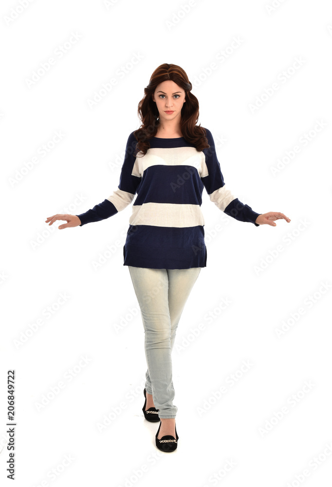 full length portrait of girl wearing striped blue and white jumper and jeans. standing pose on white studio background full length portrait of girl wearing striped blue and white jumper and jeans. standing pose on white studio background