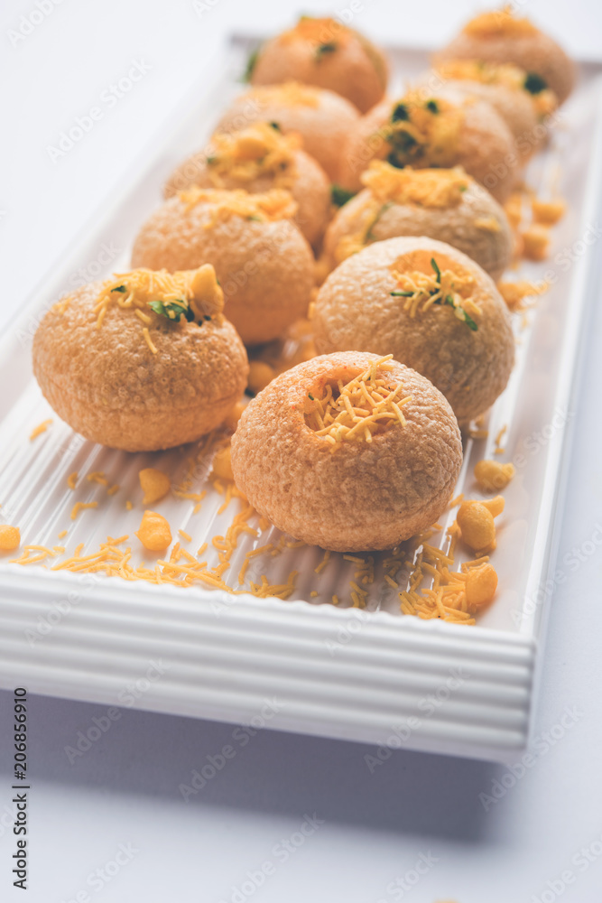 Stuffed Sev Puri is a popular Indian roadside chat item, served in a white plate. Top view, selective focus Stuffed Sev Puri is a popular Indian roadside chat item, served in a white plate. Top view, selective focus