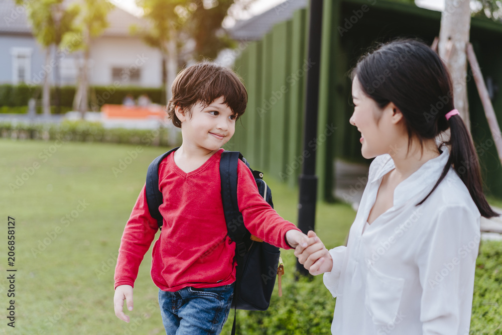 Fototapeta premium Mother get a son pupil from school after study school back to home with schoolbag family lifestyle.
