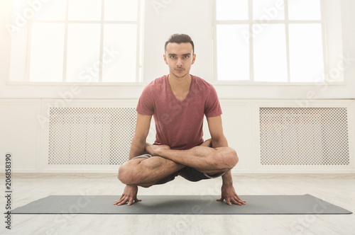 Young flexible man standing on hands photo