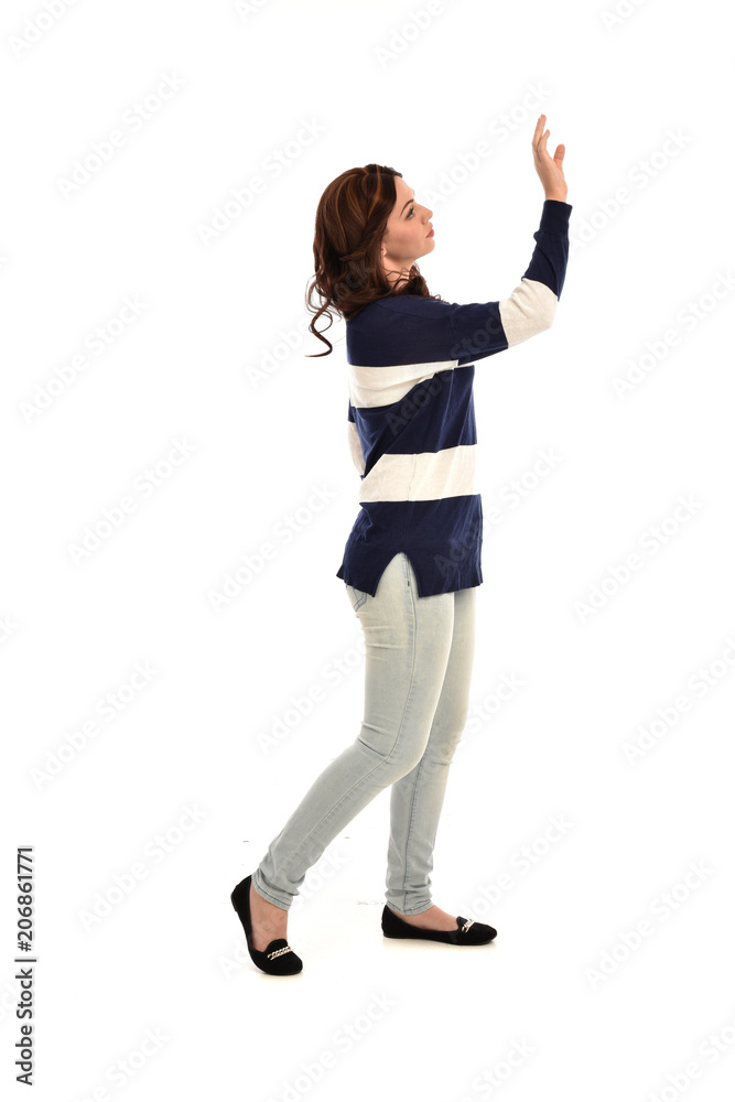 full length portrait of girl wearing striped blue and white jumper and jeans. standing pose on white studio background full length portrait of girl wearing striped blue and white jumper and jeans. standing pose on white studio background