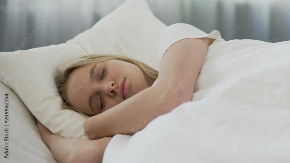 Pretty girl lying on comfortable bed linens, lazy to wake up, late for classes Pretty girl lying on comfortable bed linens, lazy to wake up, late for classes