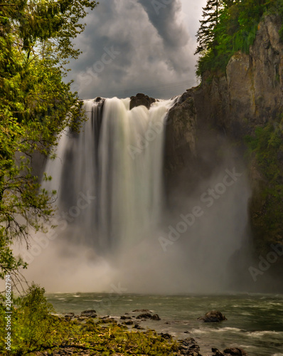 A long exposure of Snoqualmie Falls from the lower observation deck creates an image of silky water going over the falls.
