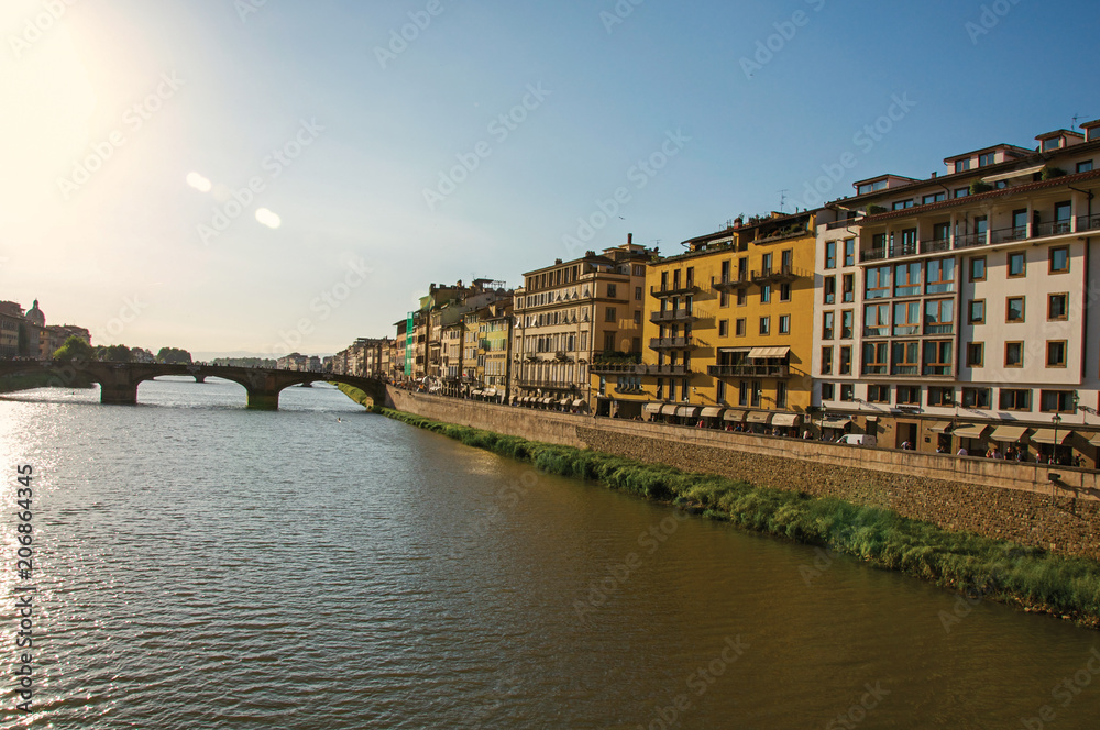 Overview of the river Arno, bridge and buildings at sunset. In the city of Florence, the famous and amazing capital of the Italian Renaissance. Located in the Tuscany region