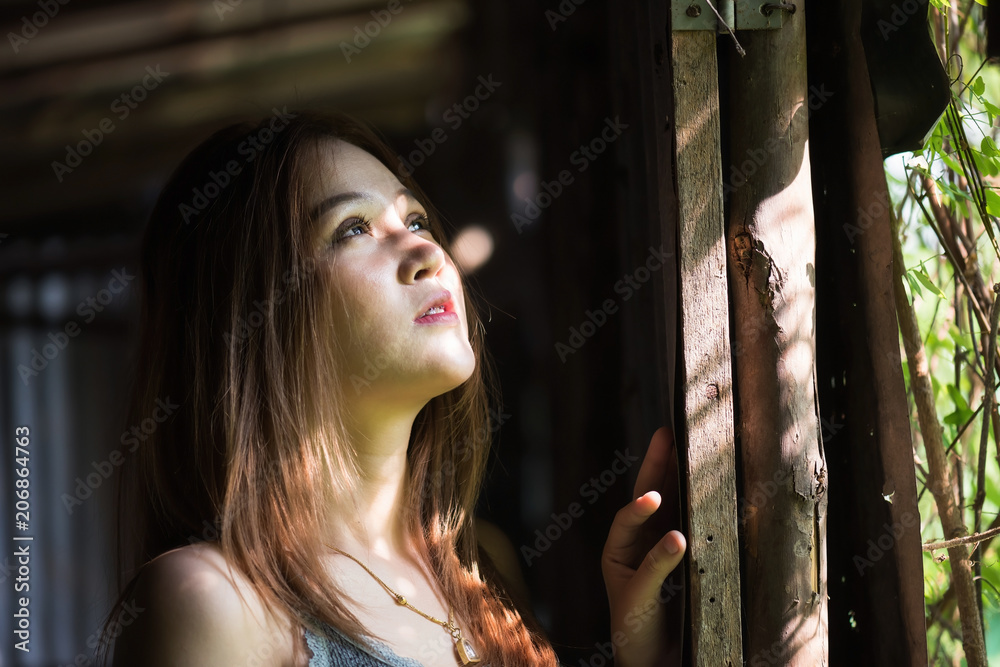 Asian girl look out with sunlight Asian girl look out with sunlight