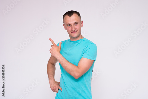 portrait of a handsome young man in a T-shirt on a white background in different poses showing in different emotions.