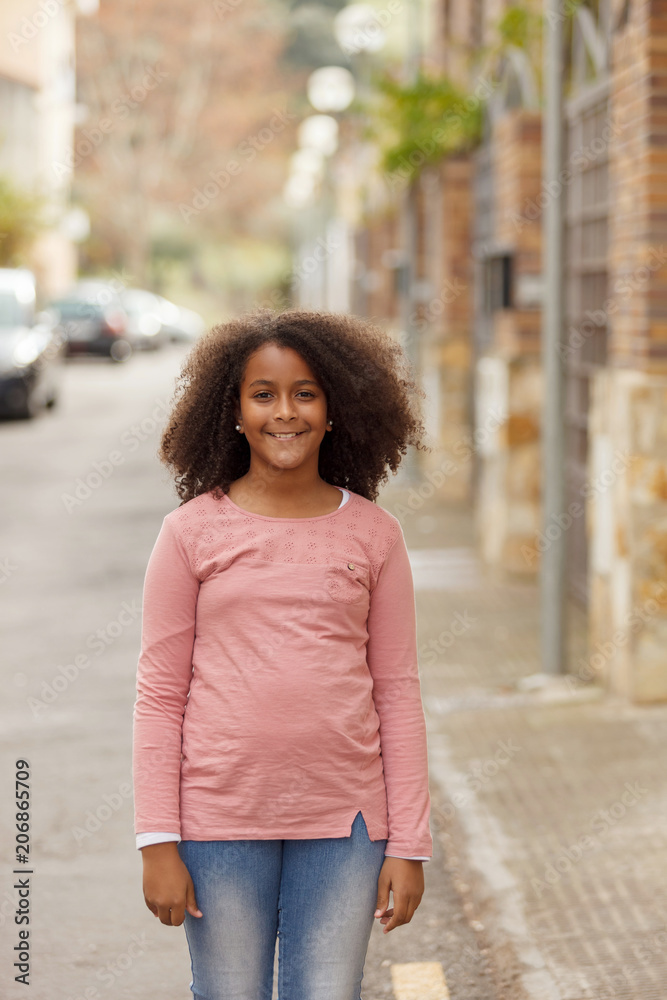 Cute African American girl in the street with afro hair Cute African American girl in the street with afro hair