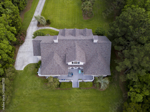 Aerial view of large home with new roof on beautiful property.