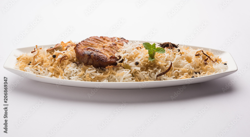 Authentic Fish Biryani served in a white plate over white background, selective focus Authentic Fish Biryani served in a white plate over white background, selective focus