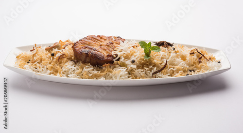 Authentic Fish Biryani served in a white plate over white background, selective focus