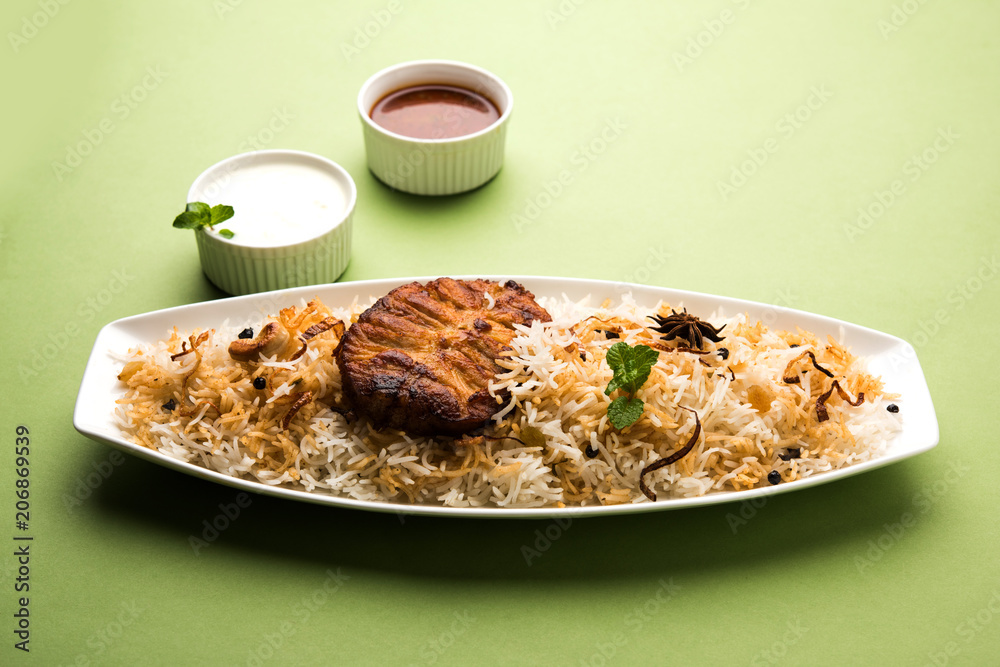 Authentic Fish Biryani served in a white plate over white background, selective focus