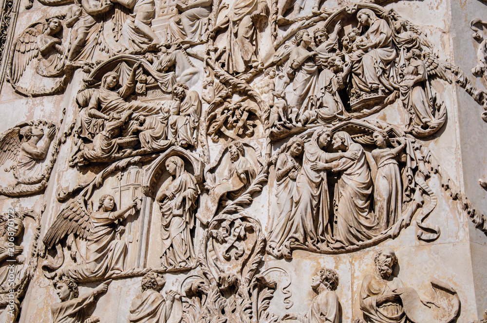 Close-up of the opulent and elaborated embossed sculptures in the Orvieto Cathedral (Duomo) on a sunny day in Orvieto, a pleasant and well preserved medieval town. Located in Umbria, central Italy