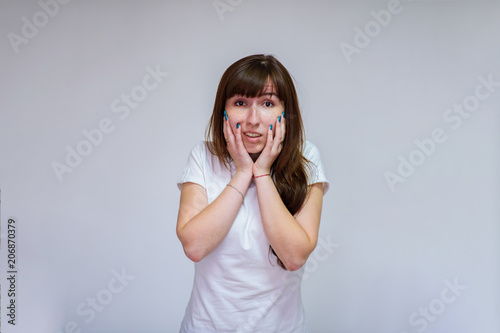 portrait of a beautiful brunette girl on a white background in different poses showing different emotions. photo