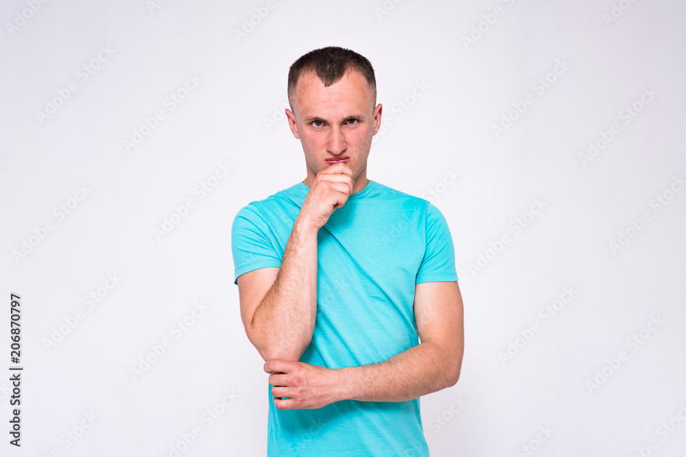 portrait of a handsome young man in a T-shirt on a white background in different poses showing in different emotions. portrait of a handsome young man in a T-shirt on a white background in different poses showing in different emotions.
