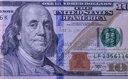 fragment of 100 dollar bill under ultraviolet lamp