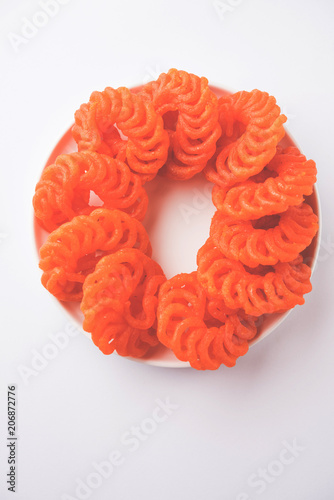 Indian sweet Imarti or Jalebi served in white ceramic plate over white background photo