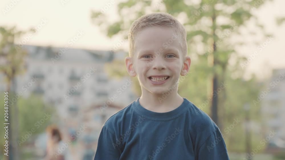 Portret of beautiful smiling boy in the park. Sun and nice nature. Slow motion Portret of beautiful smiling boy in the park. Sun and nice nature. Slow motion