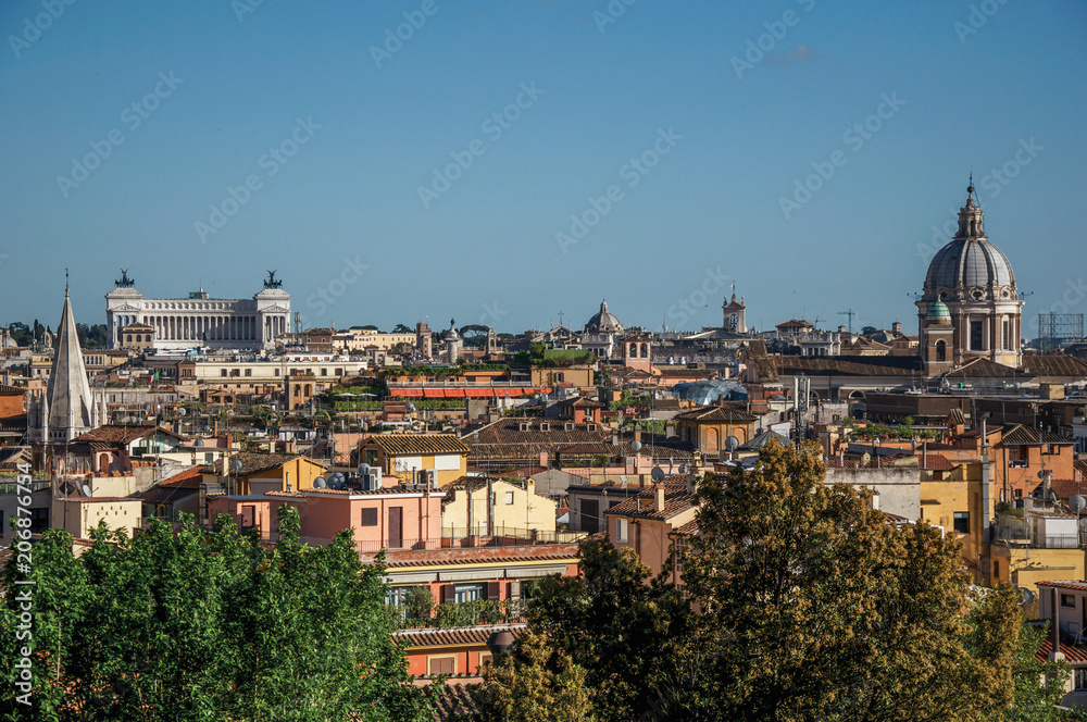 Overview of trees, cathedrals domes and roofs of buildings in the sunset of Rome, the incredible city of the Ancient Era, known as 