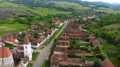 Aerial Drone 4K footage of Traditional village in Transylvania. Cloasterf Village. Medieval old church. in the village, Transylvania, Romania. Austro-Hungarian architecture. The church with a tower photo