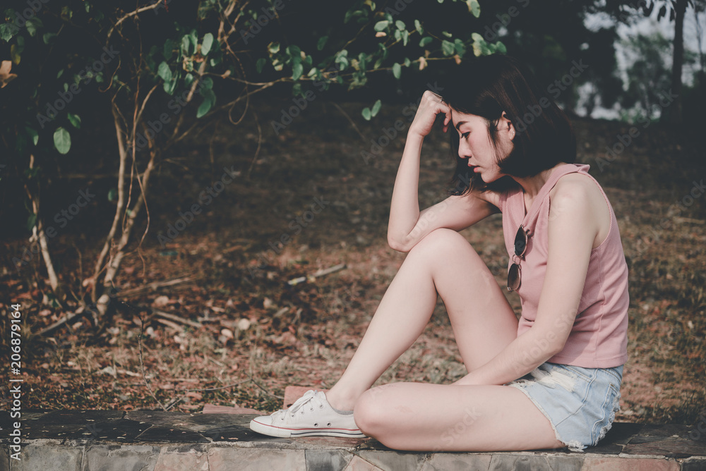 Portrait of lonely woman alone in a field. Vintage filter style.she heartbreak from love,sad girl concept on sunset vintage style