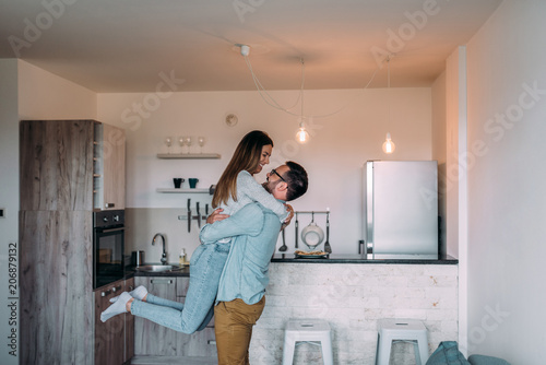 Young couple feeling euphoric and having fun in the apartment.