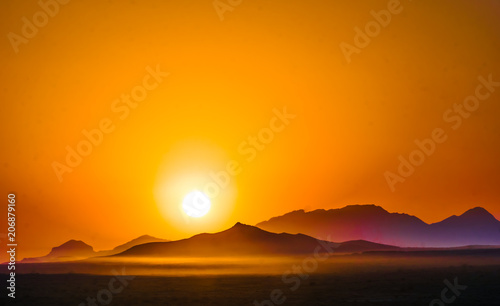Orange sunset over the mountains in the desert