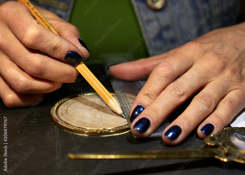 The engraver places a marking on the medal over the paste. The engraver places a marking on the medal over the paste.