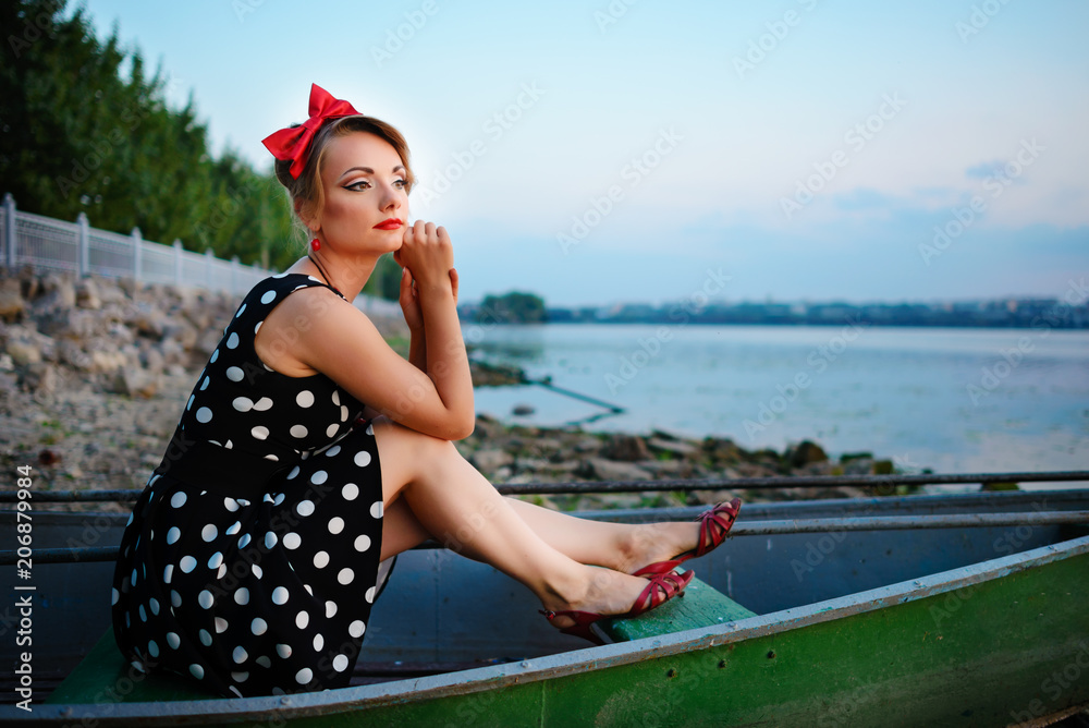 Beautiful young woman dressed dressed in a boat on a lake shore Beautiful young woman dressed dressed in a boat on a lake shore