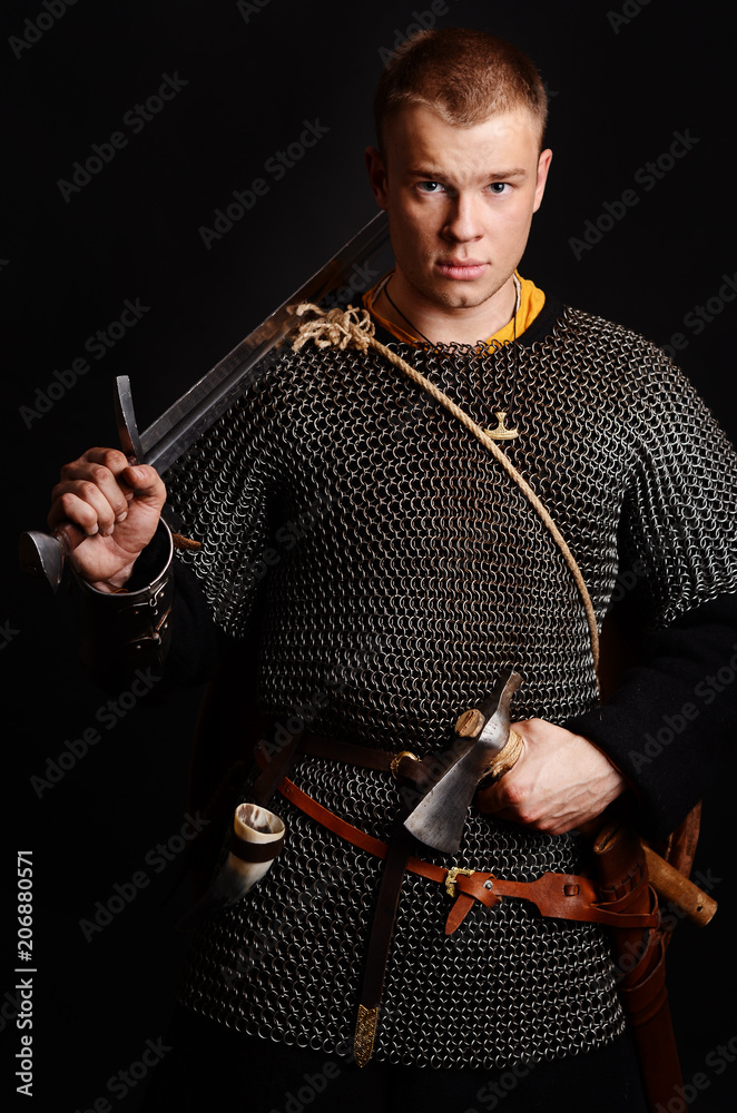 A soldier in a chain of letters stands with a sword in his hands