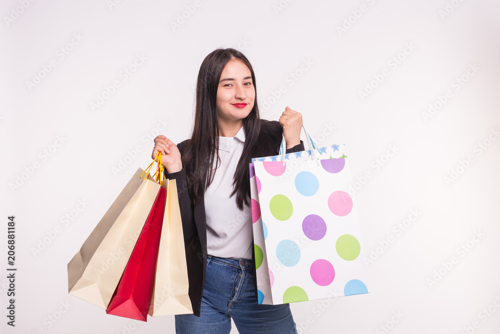 Portrait of young happy brunette woman with shopping bags on white background Portrait of young happy brunette woman with shopping bags on white background